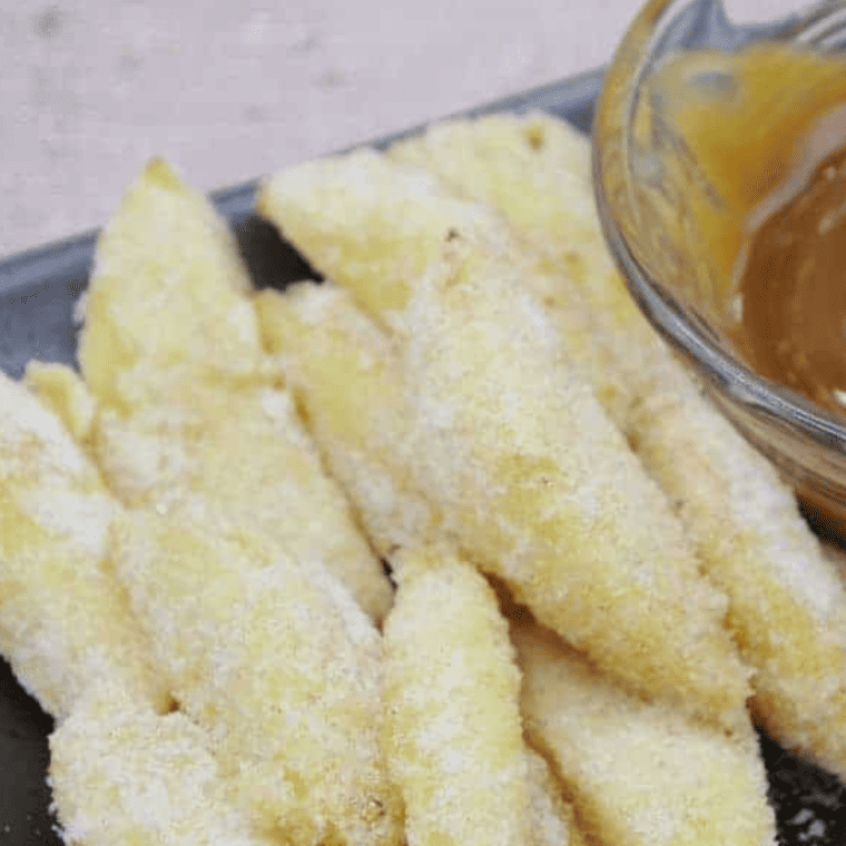 A close-up of crispy fried apples in a skillet, highlighting the sweet glaze and cinnamon flavor.