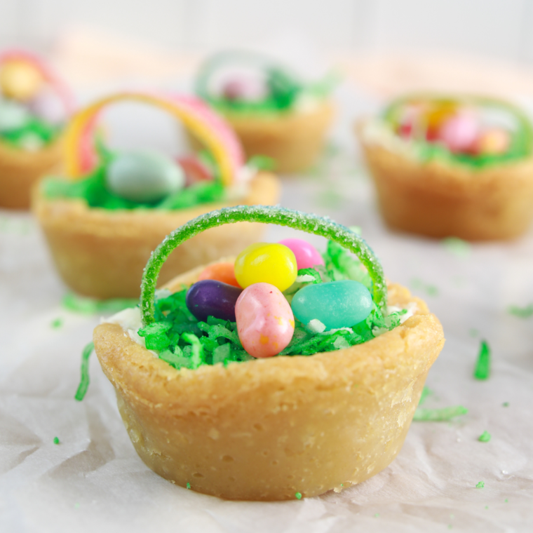 Air fryer Easter basket cookie cups filled with green coconut grass and colorful candies.