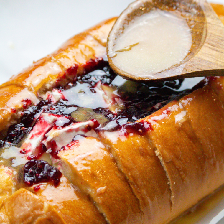 Spoon the butter over the brie, helping the bread and brie to cook up perfectly.