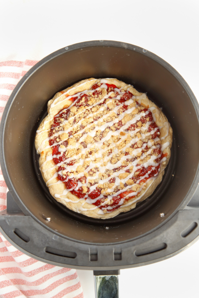 Overhead view of finished air fryer cherry dessert pizza cut into slices