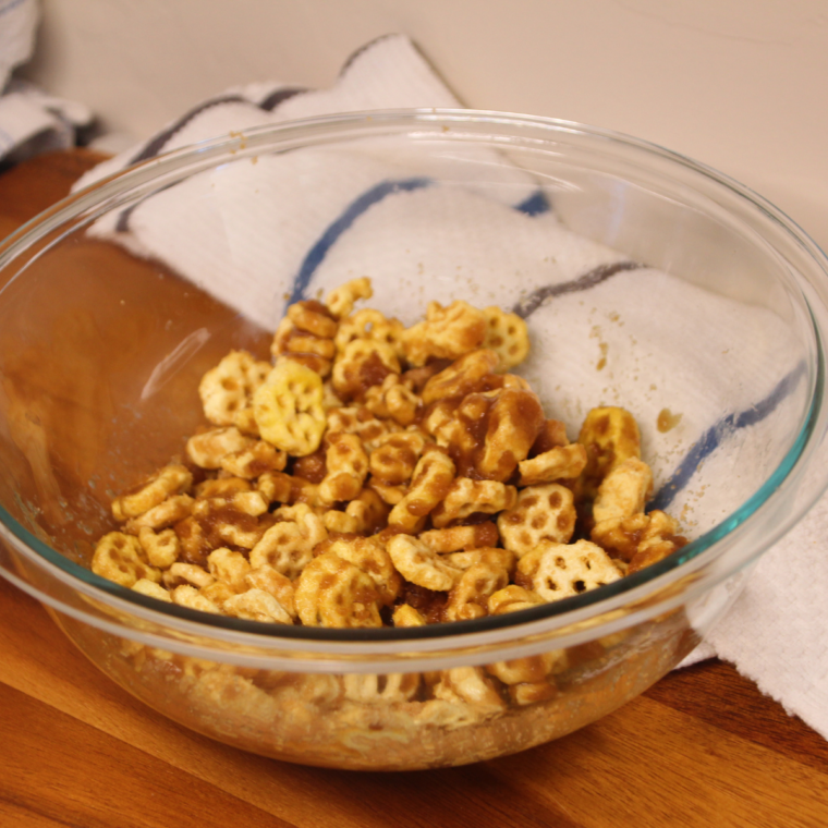 Honeycomb cereal tossed in melted butter and cinnamon sugar in a mixing bowl