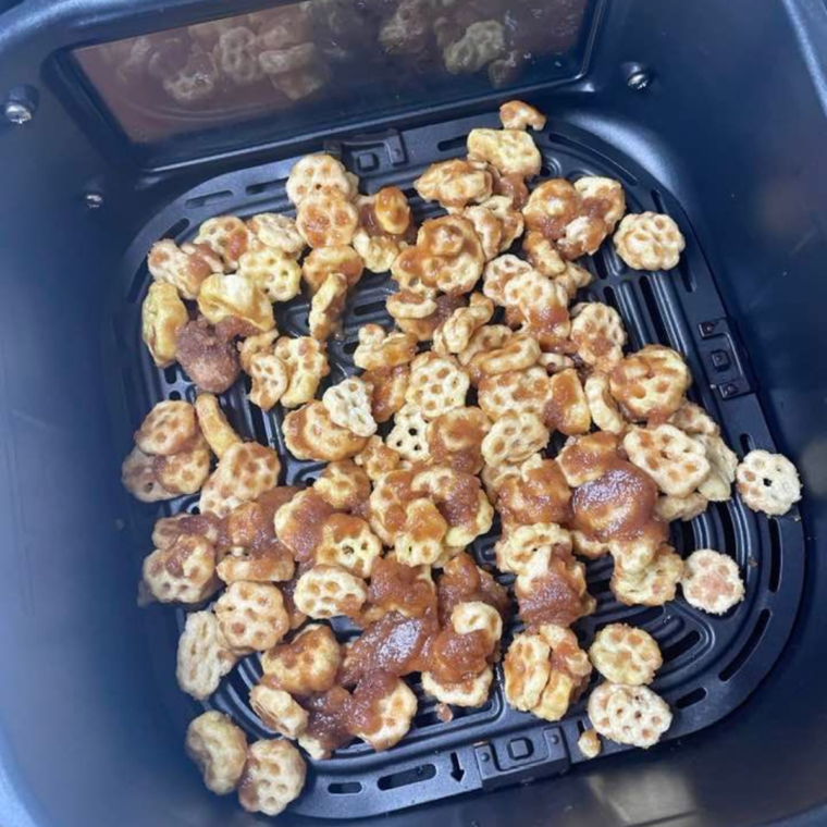 Cinnamon sugar honeycomb cereal spread in a single layer in the air fryer basket