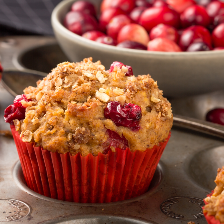 Plate with single air fryer cranberry muffin showing golden top and juicy cranberries served as a single serving breakfast.