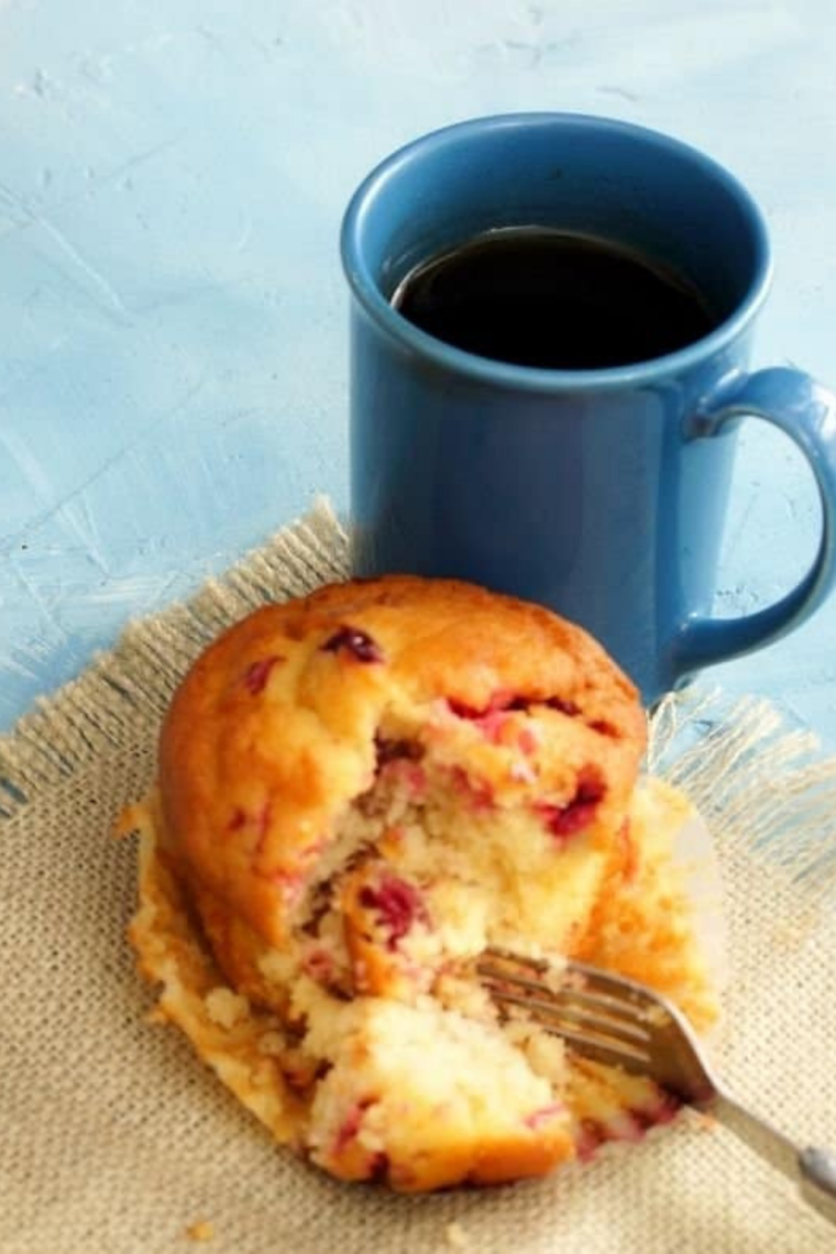 Air fryer cranberry muffin for one served on a table with golden top and visible cranberries