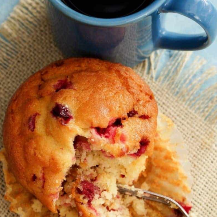 Single serving cranberry muffin made in air fryer, fluffy texture with fresh cranberries on top served in a small ramekin.