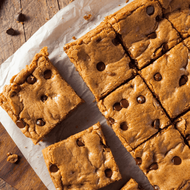 Plate of fudgy peanut butter blondies stacked with melted chocolate chips