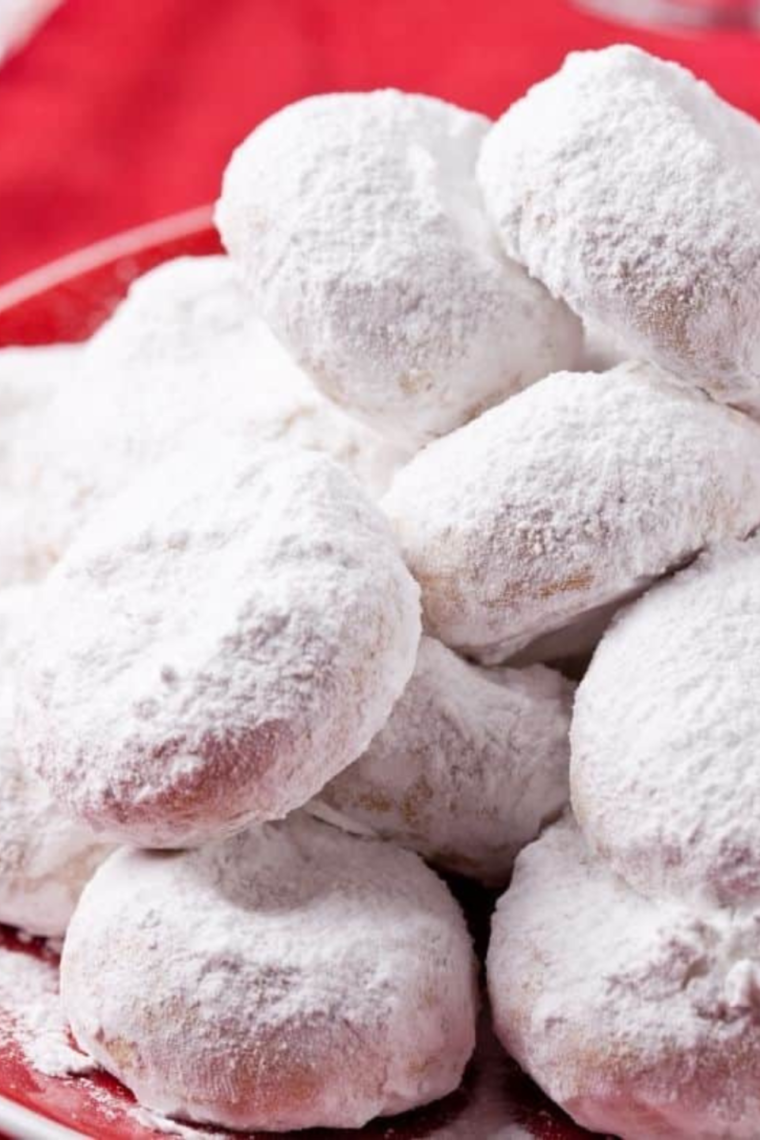 Air Fryer Greek Kourabiedes cookies shaped as crescents and dusted with powdered sugar on a plate