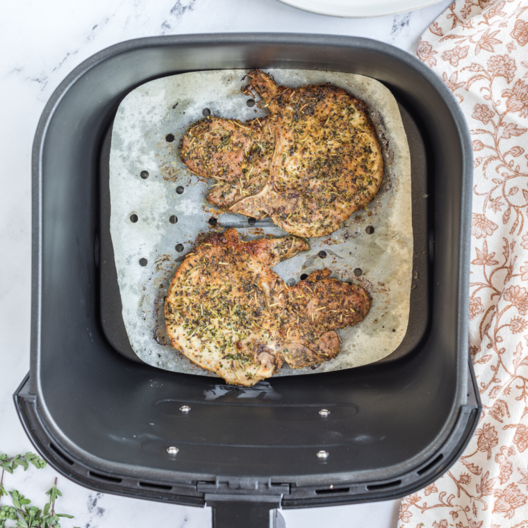 Cooked Air Fryer Italian Pork Chops in the air fryer basket.