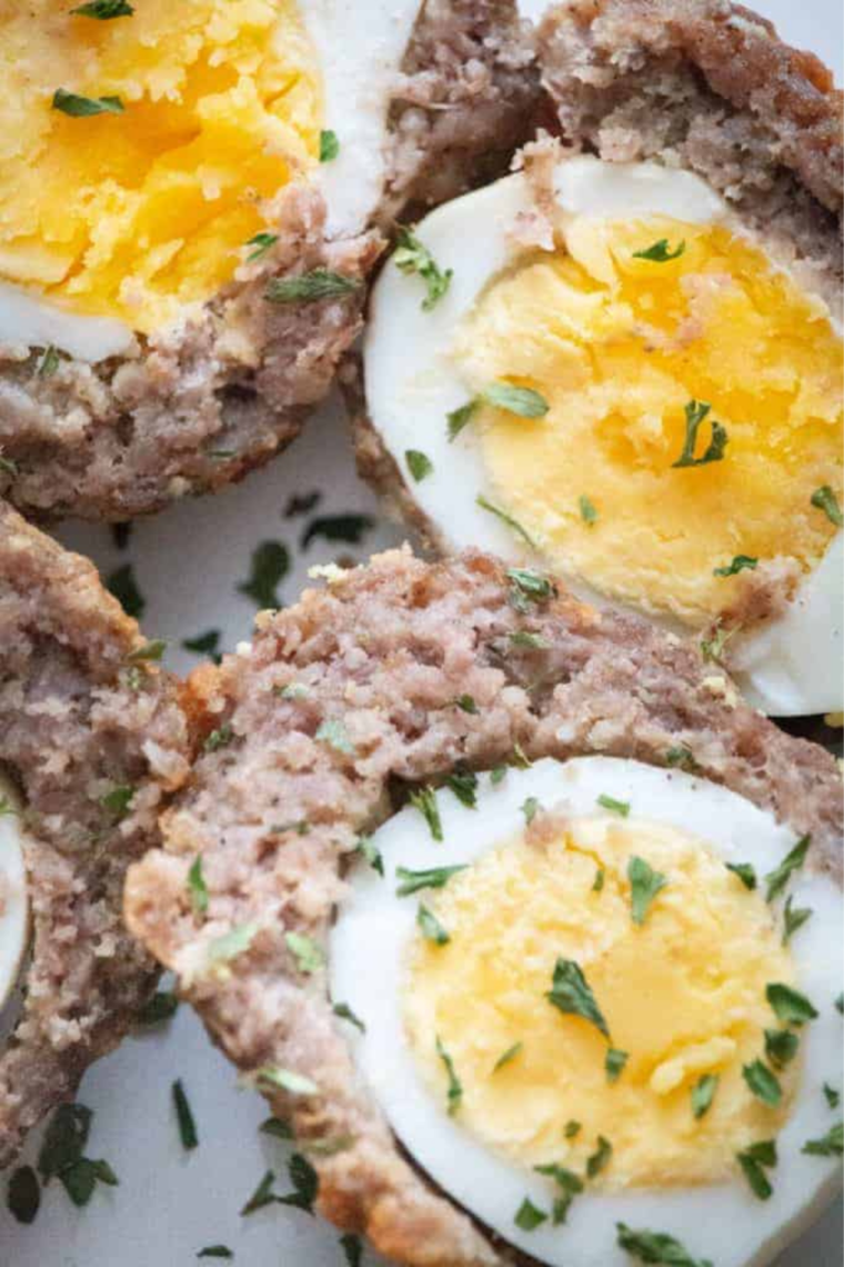 Golden-brown air fryer Scotch eggs sliced open showing cooked sausage and soft egg center