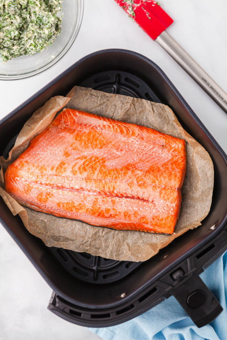 Plated sockeye salmon with fresh dill, lemon wedges, and a roasted vegetable side
