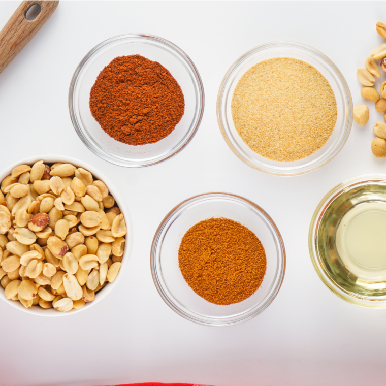 "Ingredients for Planters Heat Peanuts (Copycat) recipe, including raw peanuts, chili powder, paprika, cayenne pepper, and salt, arranged on a kitchen counter."