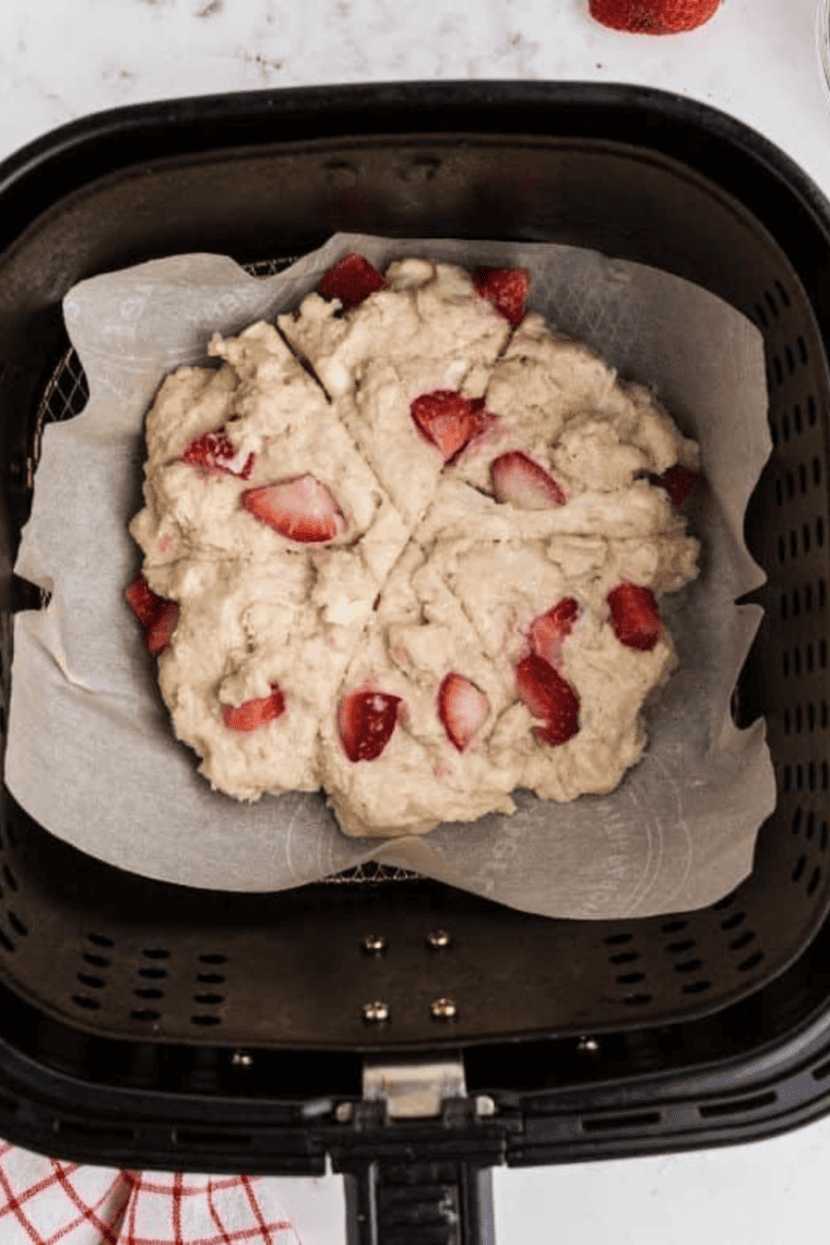 A plate of light, flaky Air Fryer Strawberry Scones filled with juicy strawberries, drizzled with glaze, and ready to enjoy.