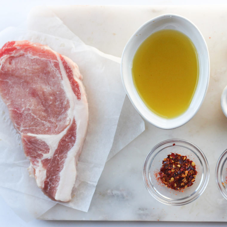 Ingredients for Blackstone pork chops: chops, olive oil, salt, pepper, and smoked paprika