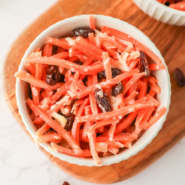 A bowl of Chick-fil-A carrot and raisin salad featuring shredded carrots, sweet raisins, and pineapple chunks in a creamy dressing.