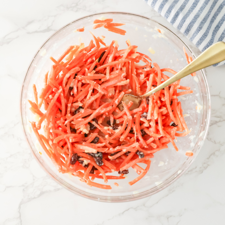 Tossing all ingredients together to create Chick-fil-A carrot and raisin salad.