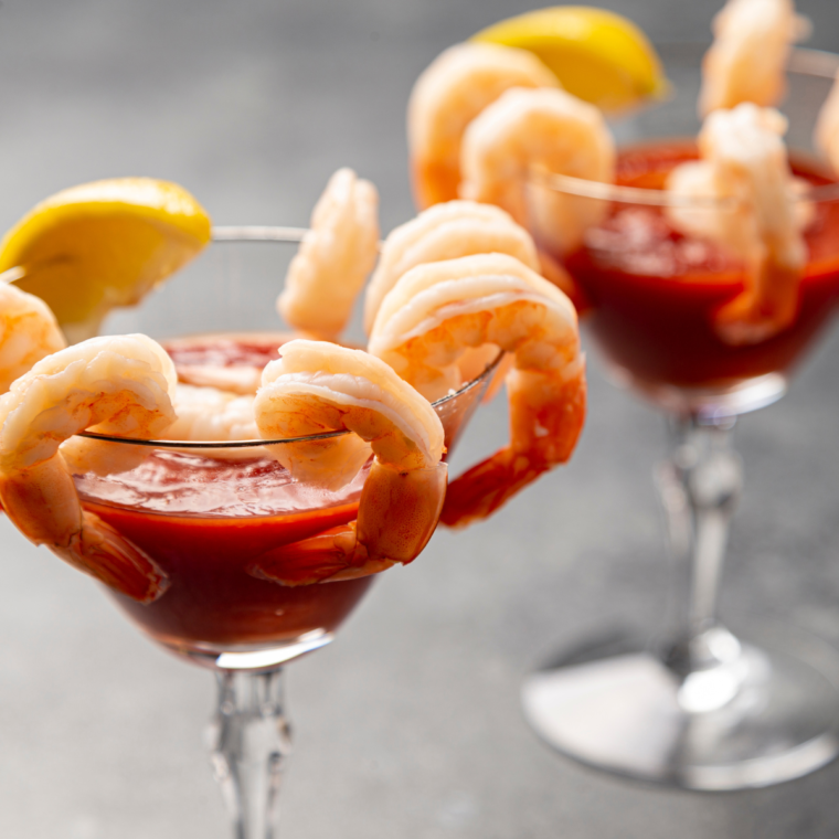 Creamy bowl of homemade cocktail sauce without horseradish served with shrimp.