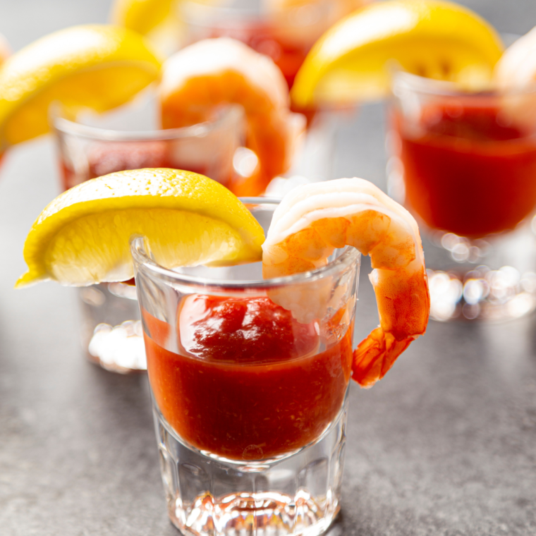 Bowl of creamy cocktail sauce without horseradish served alongside fresh shrimp.