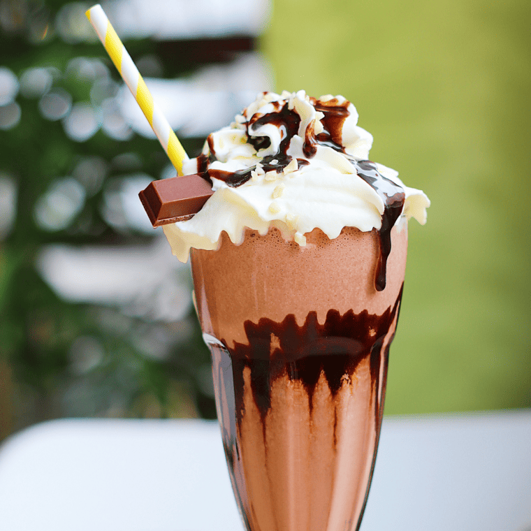 Ninja Creami Chocolate Banana Milkshake with whipped cream and chocolate drizzle.