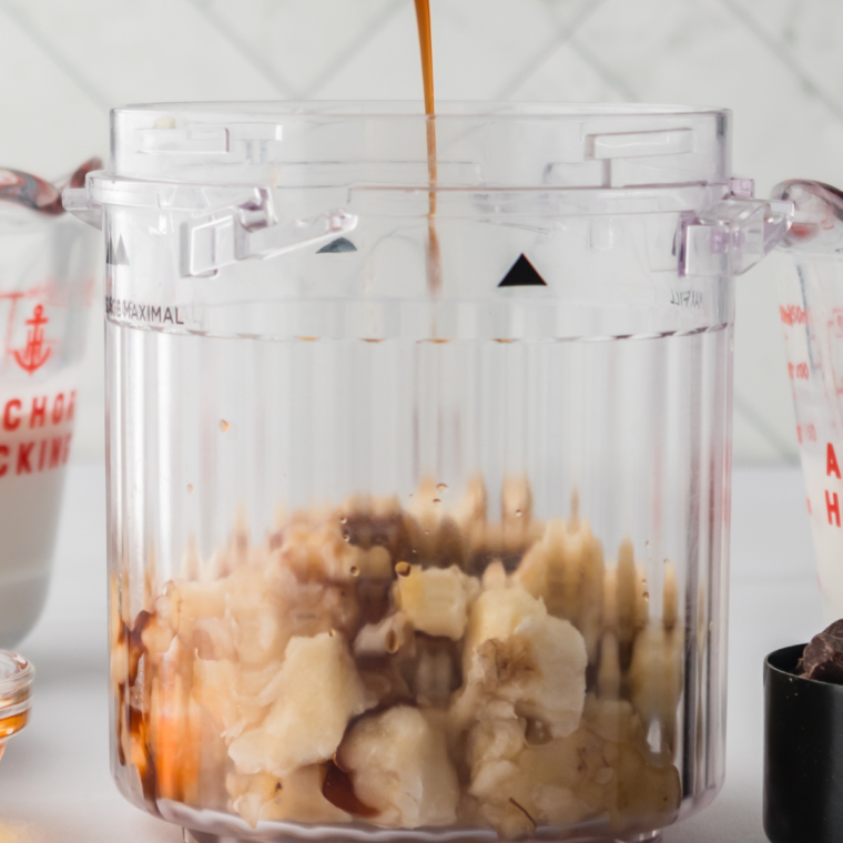 Blending mashed bananas, milk, heavy cream, and vanilla in a Ninja Creami pint container until smooth.
