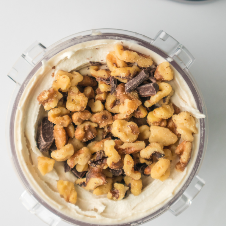 Adding chocolate chunks and walnuts into the hole of Ninja Creami ice cream, then mixing them in using the Mix-In function.