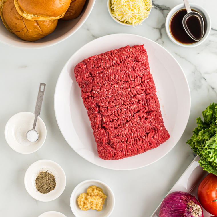 Mixing ground beef with seasonings and forming burger patties.