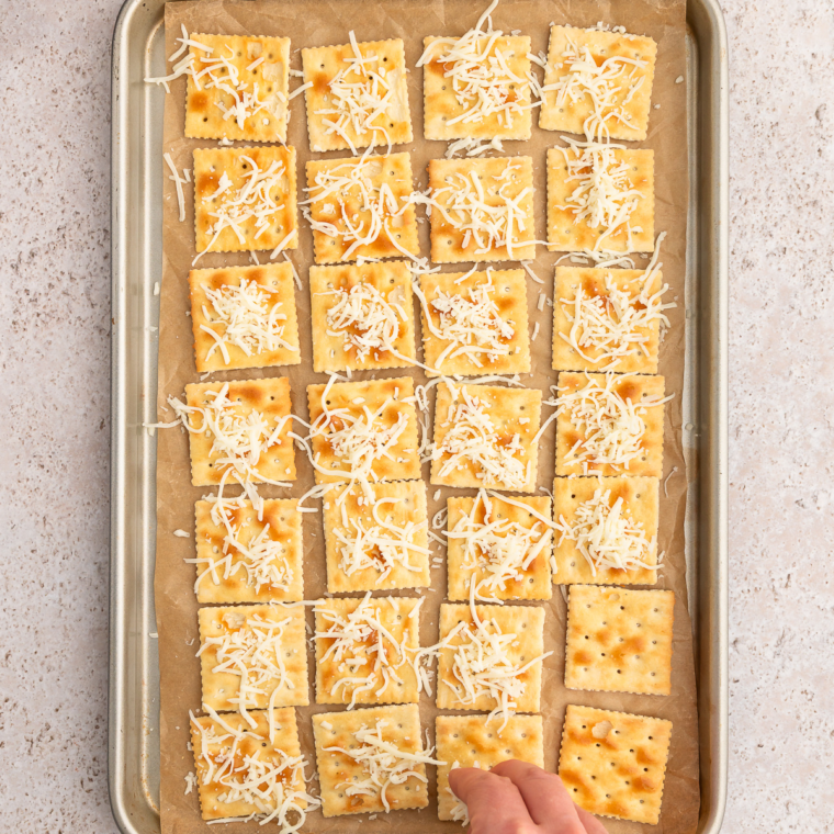 Saltine crackers topped with shredded cheese and Old Bay seasoning before air frying