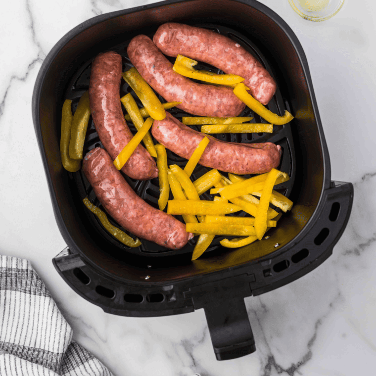 Trader Joe's hot Italian sausage browning in a 12-inch skillet with crusty edges and visible fennel seeds