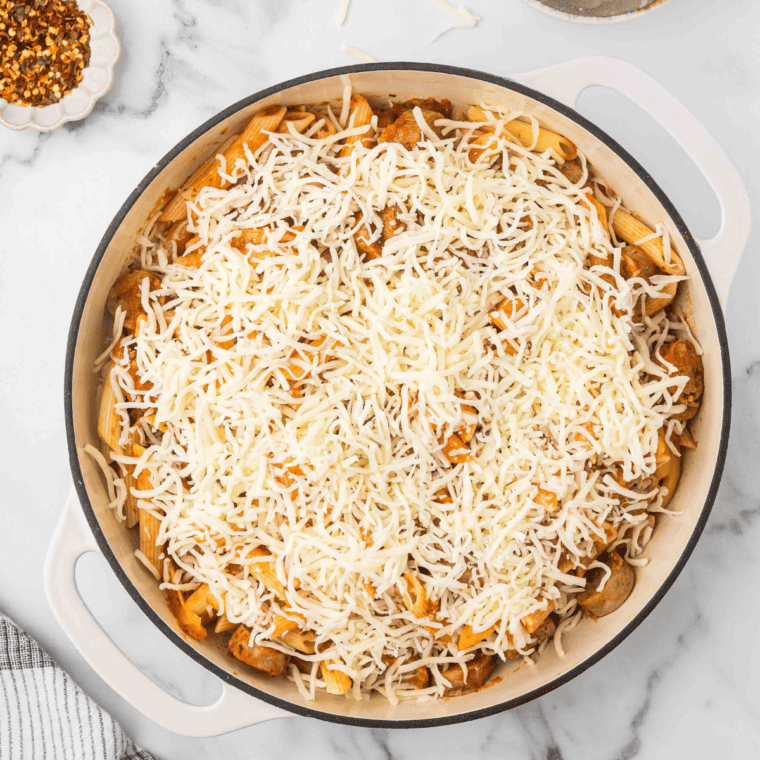 Final pasta with melted mozzarella on top, served in skillet, parsley garnish.