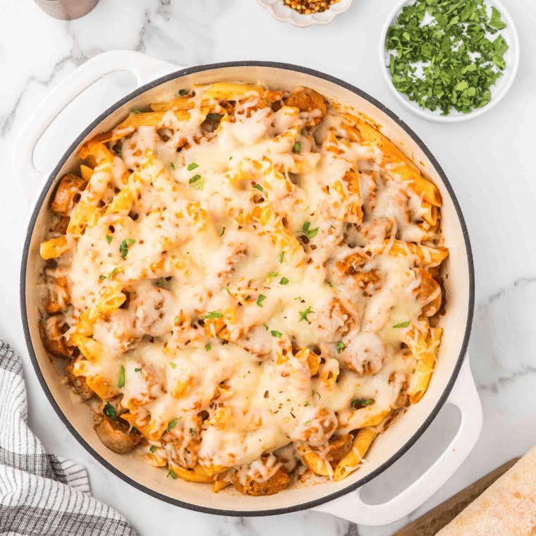 Plate of Trader Joe’s sausage pasta with savory sauce and herbs, ready to serve.