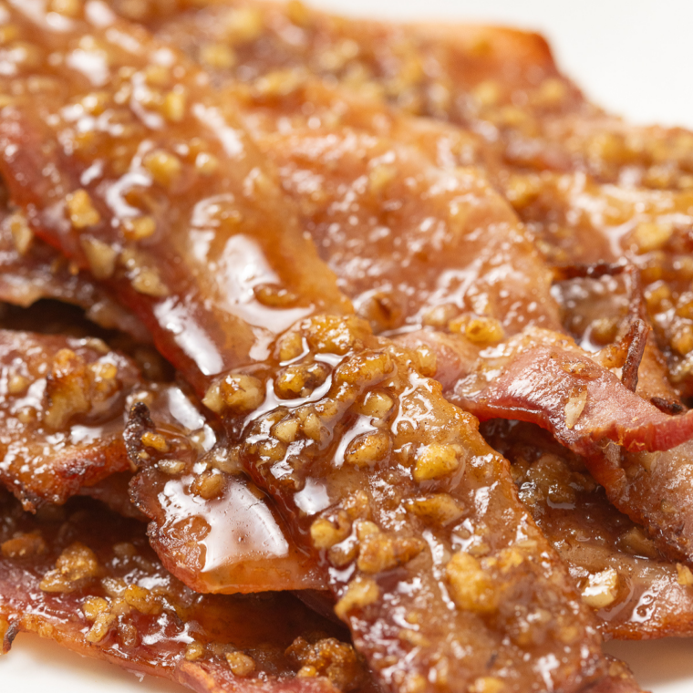 Crispy air fryer bacon strips arranged on a white plate