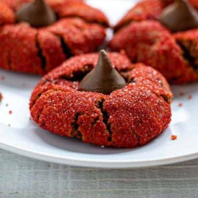 Plate of Air Fryer Red Velvet Peanut Butter Blossom Cookies with soft red cookies and peanut butter centers.
