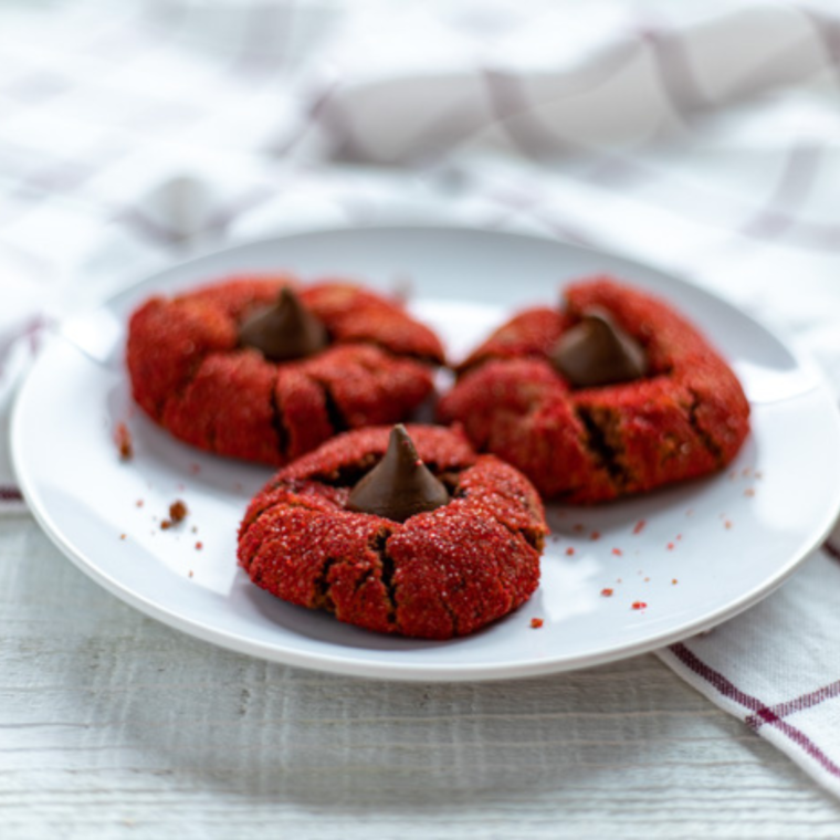 Close up of Air Fryer Red Velvet Peanut Butter Blossom Cookies on white plate.