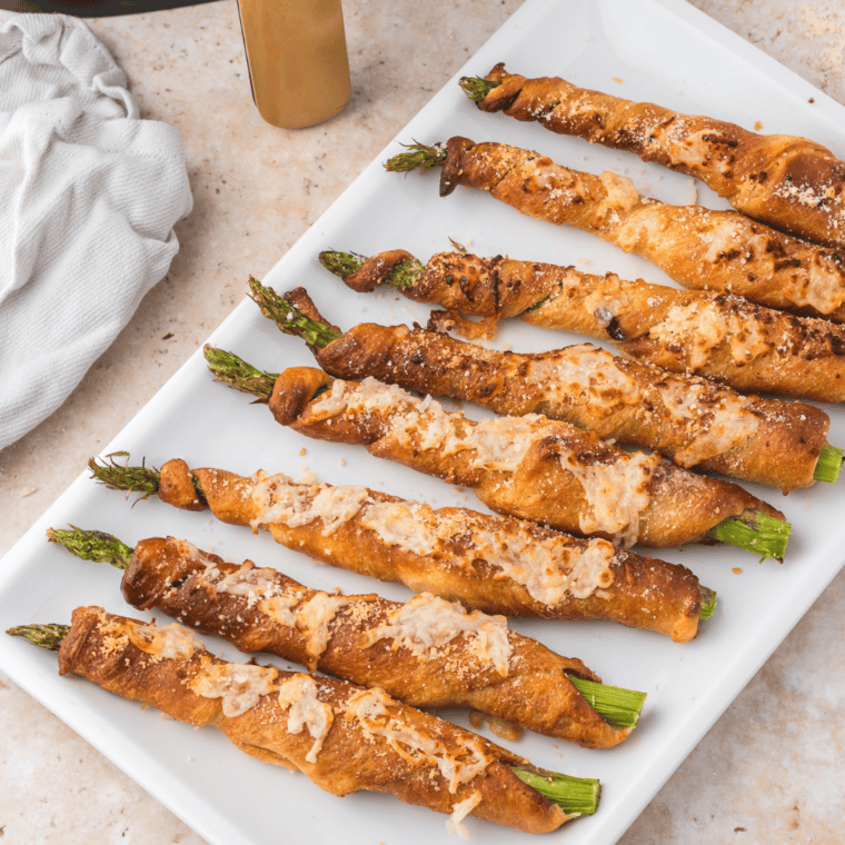 Air fryer asparagus crescent rolls golden brown, filled with tender asparagus and sprinkled with Parmesan cheese, ready to serve as a delicious snack or appetizer.