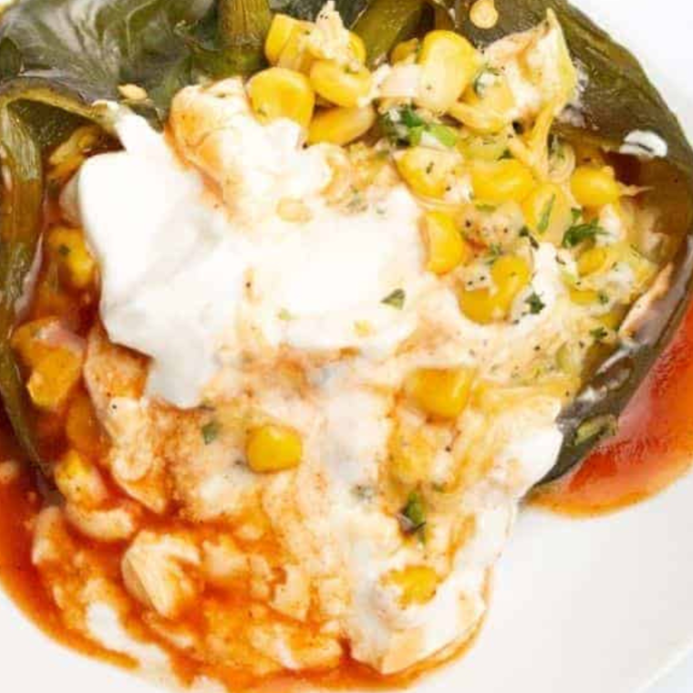 Cheese-stuffed air fryer chile relleno served golden brown with fresh herbs and salsa on the side.