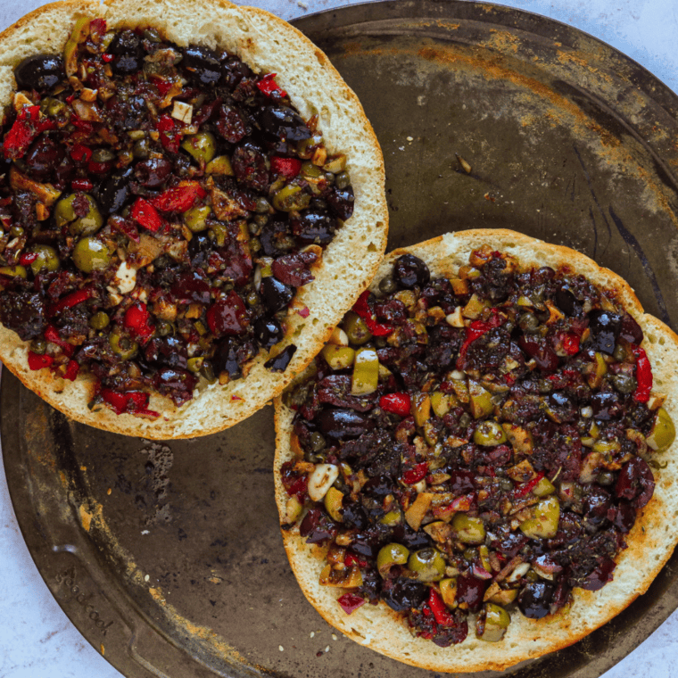 Add the olive spread onto the bread, and then add the fillings.