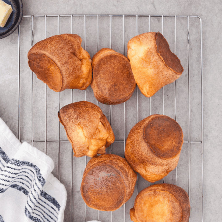 Golden, fluffy air fryer popovers freshly baked and puffed, served on a plate