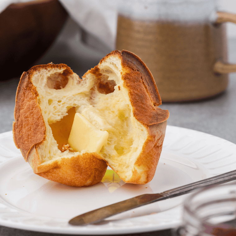 Golden, airy air fryer popovers freshly baked and served on a plate