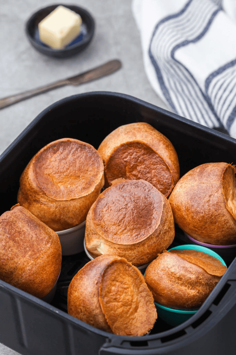 Golden, fluffy air fryer popovers freshly baked, puffed, and served on a plate
