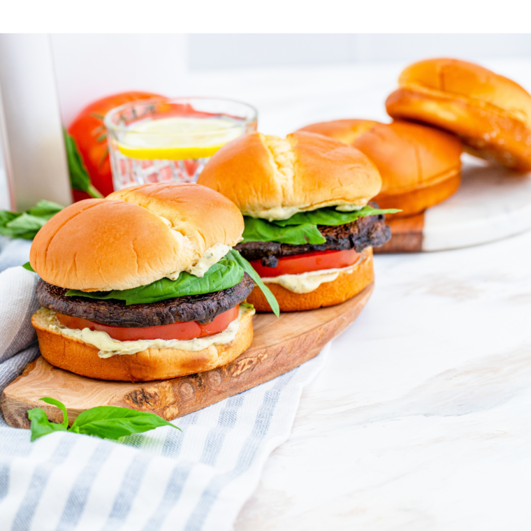 Assembled Air Fryer Portobello Mushroom Burger with toppings of lettuce, tomato, and melted cheese, served on a sesame seed bun."