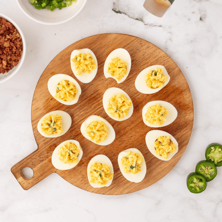 Close-up of creamy million dollar deviled eggs garnished with paprika and bacon
