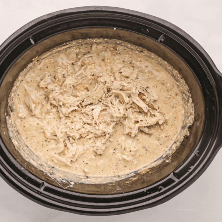 Shredding cooked chicken breast with two forks for crockpot shredded chicken