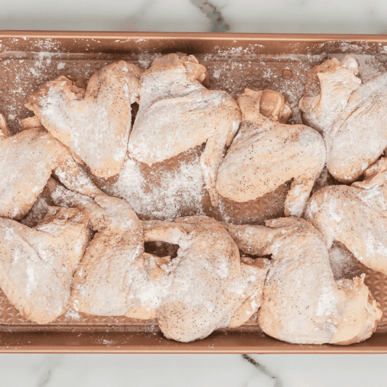 Chicken wings arranged in air fryer basket, cooking to crispy perfection.