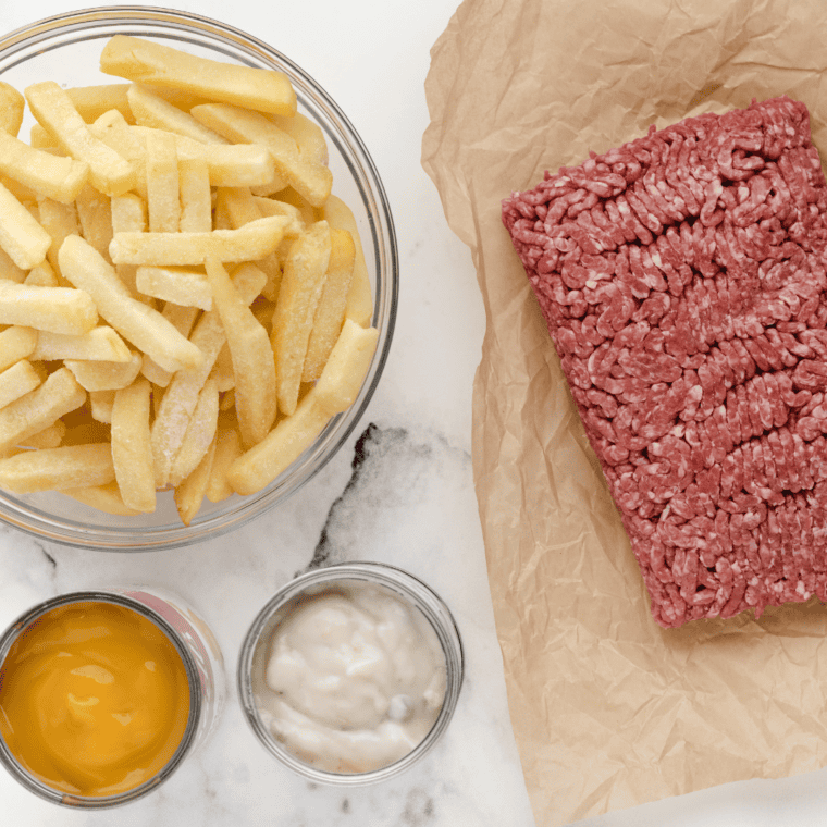 Ingredients for cheeseburger French fry casserole: ground beef, frozen fries, condensed soups, and seasonings