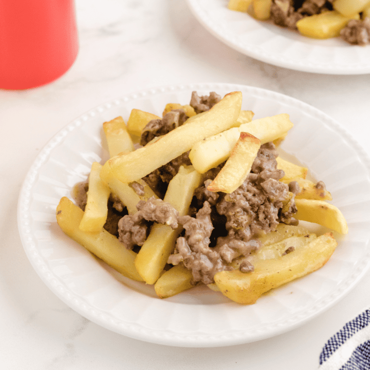 Scoop of cheeseburger French fry casserole showing cheesy beef and crispy fry topping