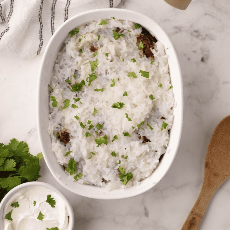Air fryer chicken biryani layered with spiced rice and tender chicken, garnished with herbs and fried onions.