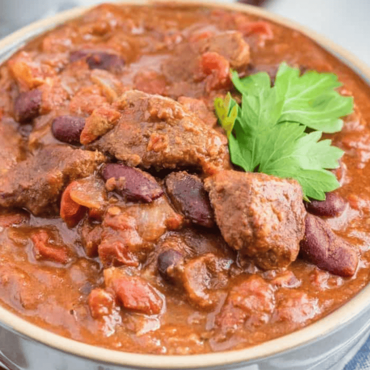 Finished dish - A close-up of the cooked Air Fryer Chili Con Carne, served in a bowl, garnished with toppings like sour cream and green onions.