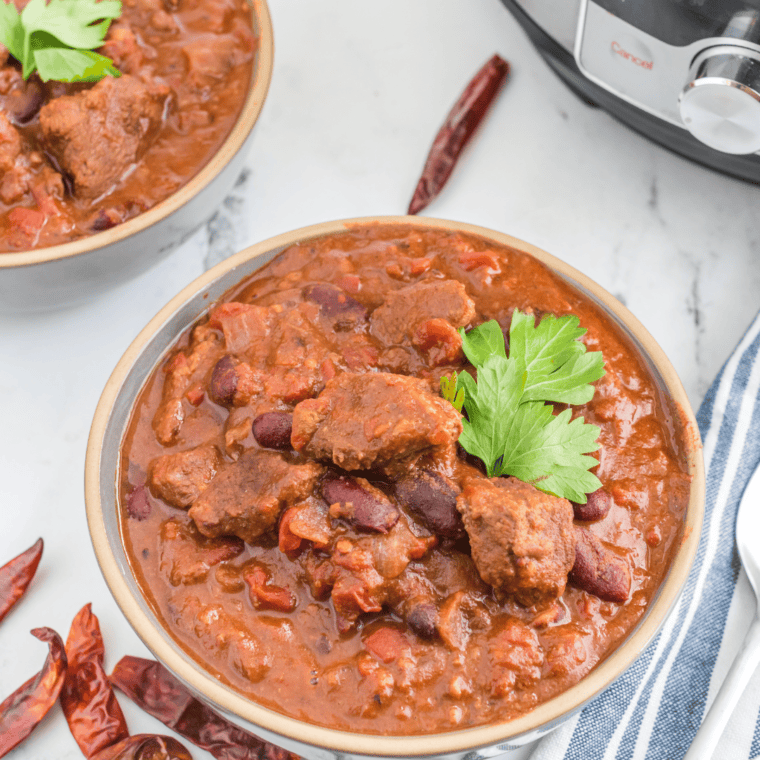Close-up of Chili in a Bowl - A vibrant bowl of Air Fryer Chili Con Carne, filled with a hearty mix of ground beef, beans, and tomatoes, garnished with fresh cilantro and a dollop of sour cream.