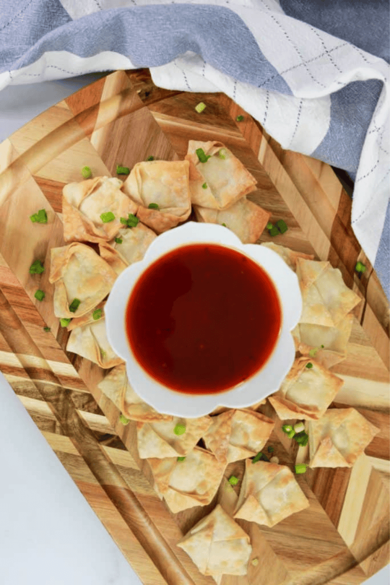 Golden, crispy Air Fryer Cream Cheese Rangoon served on a plate with a delicious cream cheese filling.