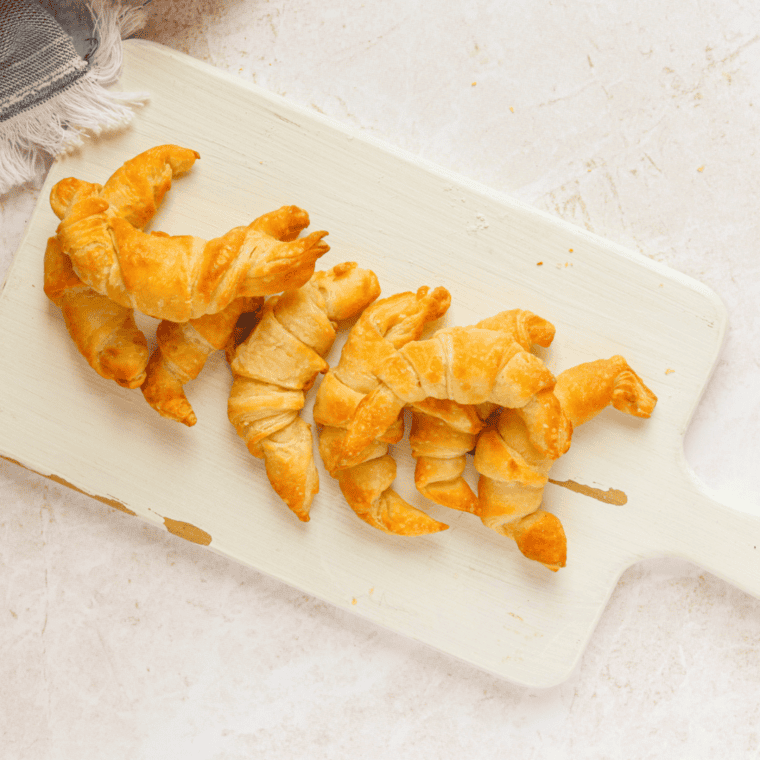 Golden, flaky homemade croissants baked in the air fryer on a plate.