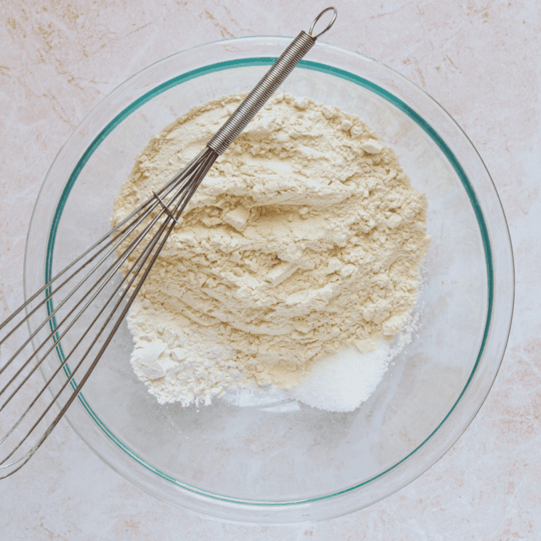 Mixing flour, baking powder, and salt together in a bowl to prepare croissant dough.